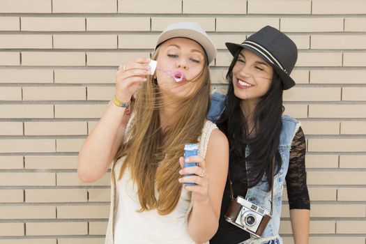 Teenage firends playing with soap bubbles