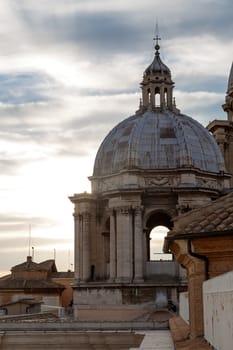 Close up detailed dome view of Saint Peter's Basilica in Vatican, on cloudy blue sky background.