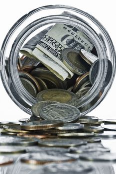 Close up view of container filled with coins on white back