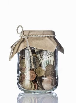 Close up view of container filled with coins on white back