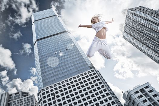 Portrait of young jumping woman on blue sky background