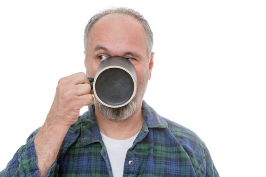 Single balding middle aged bearded man drinking from mug in front of his mouth as he looks over to his side on white background