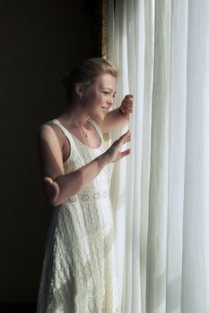 portrait of young  beautiful woman looking in the window