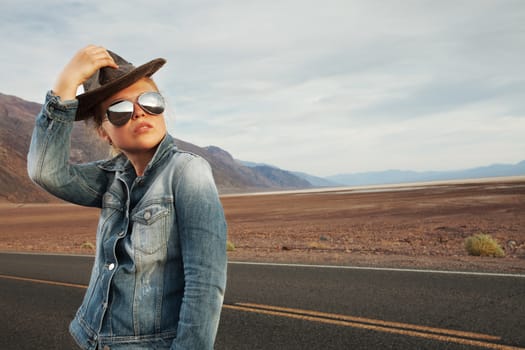 portrait of young beautiful girl in hat and sunglasses in desert  environment