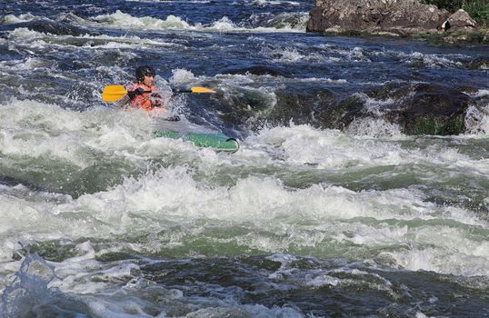 Kayaker in the  whitewater of a river Umba in Russia