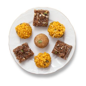 Indian sweets on a plate isolated over white