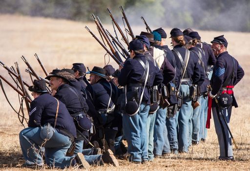 A line of American Civil War infantry from the Northern States fire in line at the Confederate troops across the field at Hawes Farm in northern California.nPhoto taken on: October 03rd, 2015.