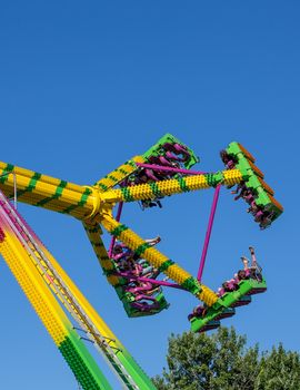 Anderson, California, USA- June 17, 2015: Fair goers enjoy the carnival ride Freak Out at the Shasta County FairThe Freak Out is a pendulum shaped ride that is very popular.