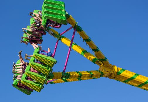 Anderson, California, USA- June 17, 2015: Fair goers enjoy the carnival ride Freak Out at the Shasta County FairThe Freak Out is a pendulum shaped ride that is very popular.