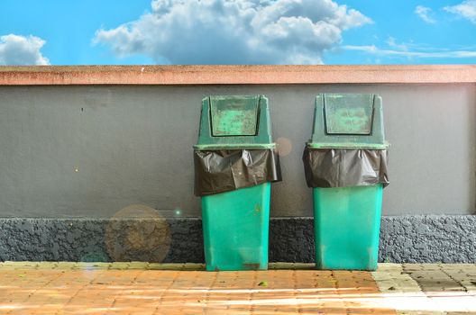 Green trashcan for keeping garbage on blue  sky