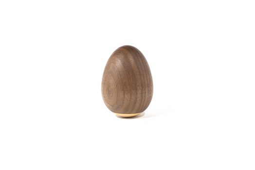 Dark walnut wooden egg on white background