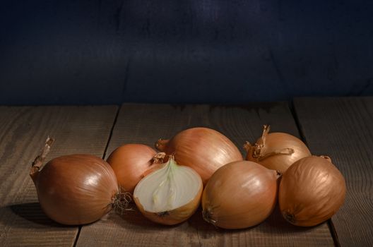 Raw whole onions on the old boards. Place for text.