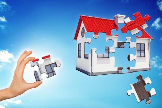 Hand making house puzzle on blue sky