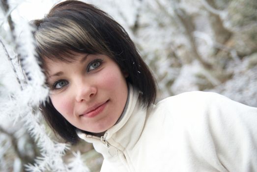 Pretty winter girl in the snow forest