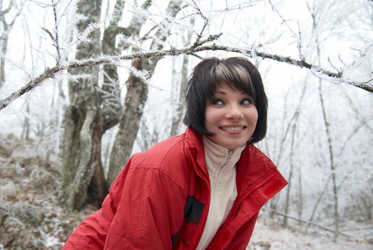 Pretty winter girl in the snow forest