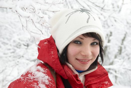 Pretty winter girl in the snow forest