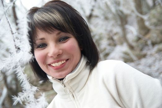 Pretty winter girl in the snow forest