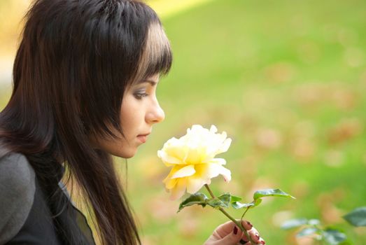 Beautiful girl with yellow rose, soft background