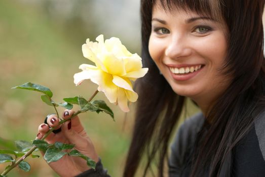 Beautiful girl with yellow rose, soft background