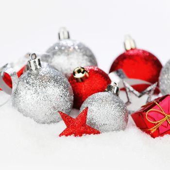 Red and silver christmas balls and decoration on snow