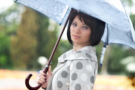 Pretty girl with umbrella in the garden