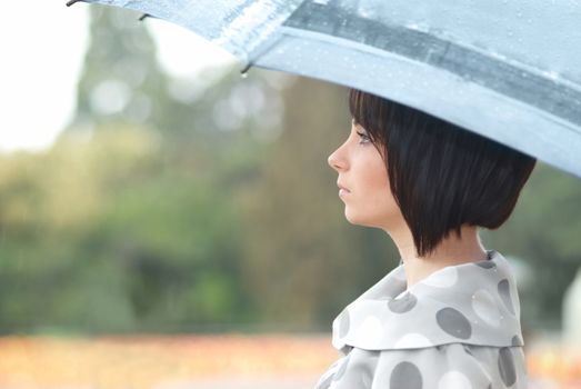 Pretty girl with umbrella in the garden