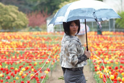 Pretty girl with umbrella in the garden