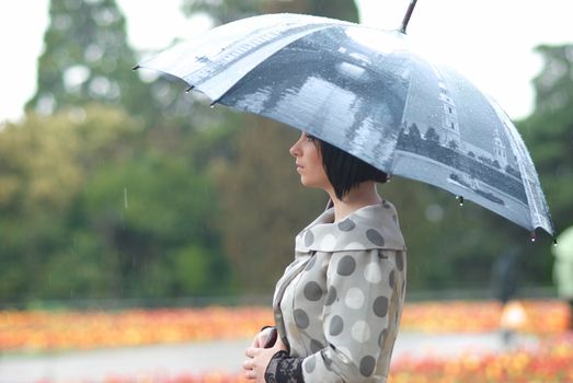 Pretty girl with umbrella in the garden