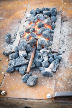 Iron rod put to heat between the hot coals.