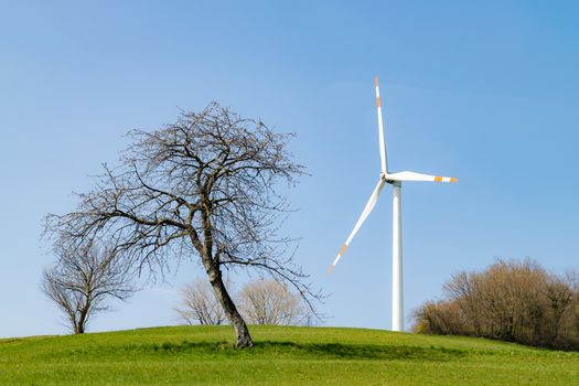 Wind turbine installed on a green hill.