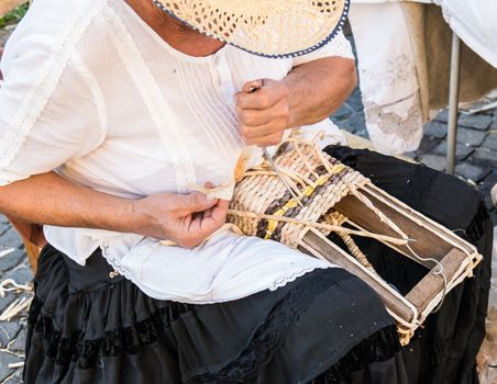 Elderly lady builds bags woven by hand using the dried leaves of the corn cobs.