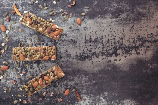 Healthy snack. Homemade granola bars with nuts and dried fruit.Top view, vintage toned image, blank space.