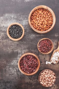 Many different types of dried beans with scoop. Top view, vintage toned image, blank space