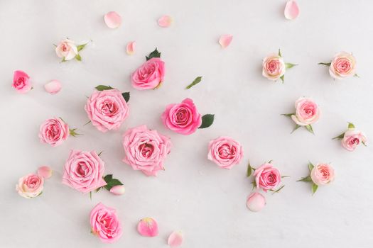 Various soft roses and leaves scattered on a vintage background, overhead view