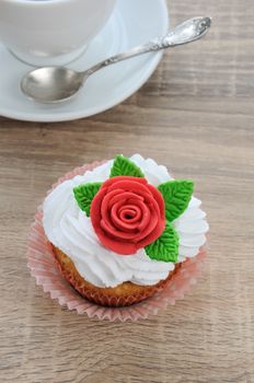 muffin of whipped cream decorated with marzipan rose