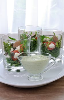 Mayonnaise sauce in a gravy boat with dill salad of arugula