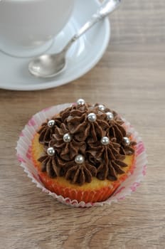 Muffin decorated with chocolate cream in paper packaging