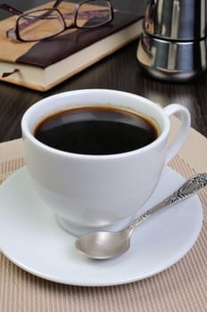 Coffee cup with   notepad and glasses on a table