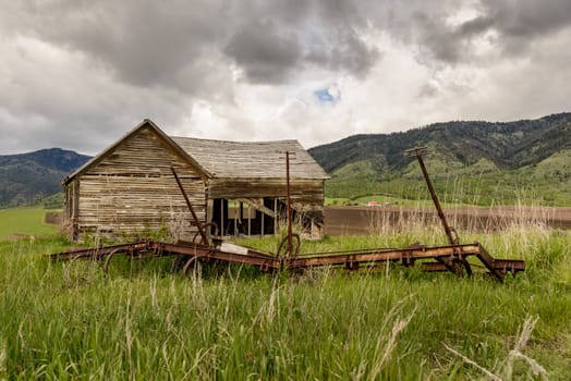 Old abandoned farm in Wyoming, United States. Spring with cloudy sky.