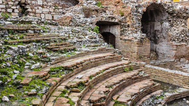 A detail of the ruins of Odeon, the ancient greek theater of taormina, in sicily, landscape cut.