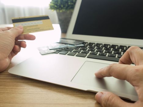 close-up human's hand using laptop computer for shopping online at home.