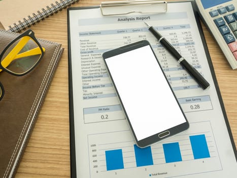 smart phone on work desk with notebook ,report, pen.