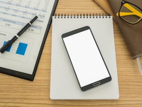 smart phone on work desk with notebook ,report, pen.