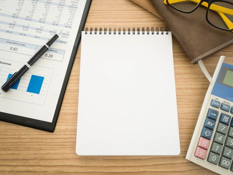 Notebook on the desk with the analysis report , Pens, calculators.