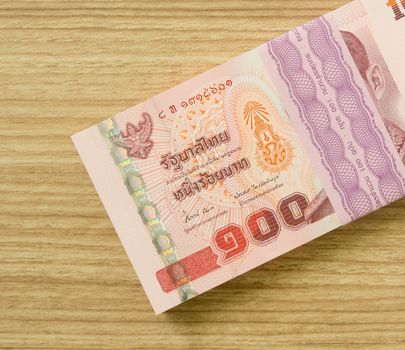 one hundred  thai banknotes put on table .  money concept