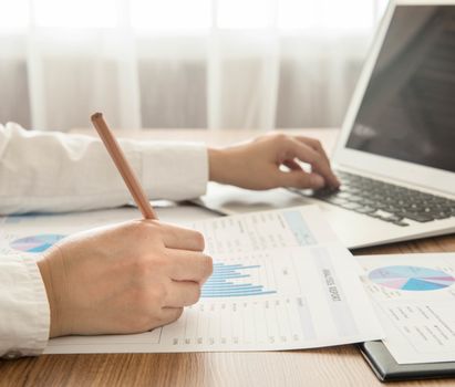 Businessmen are analyzed data from report and a laptop computer.