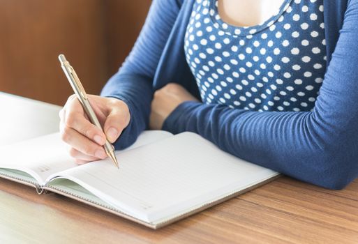 women are taking notes in a notebook. select focus.