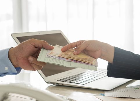 Businessmen are loan payment to the bank employees.