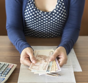 Women  counting money to pay  or invest or deposit.