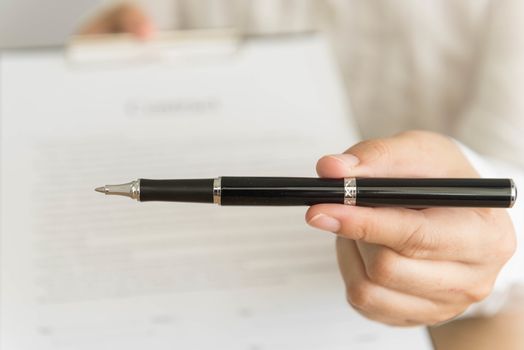 Businessman handing  a contract attached  for signature  and pen in his hand. selective focus.